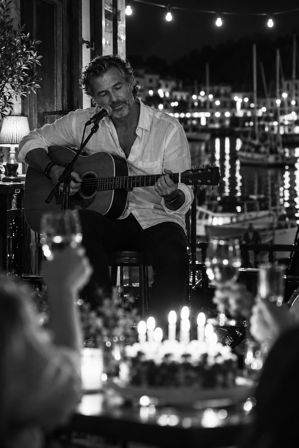Milo Falk spielt Gitarre bei einem Abendkonzert am Hafen